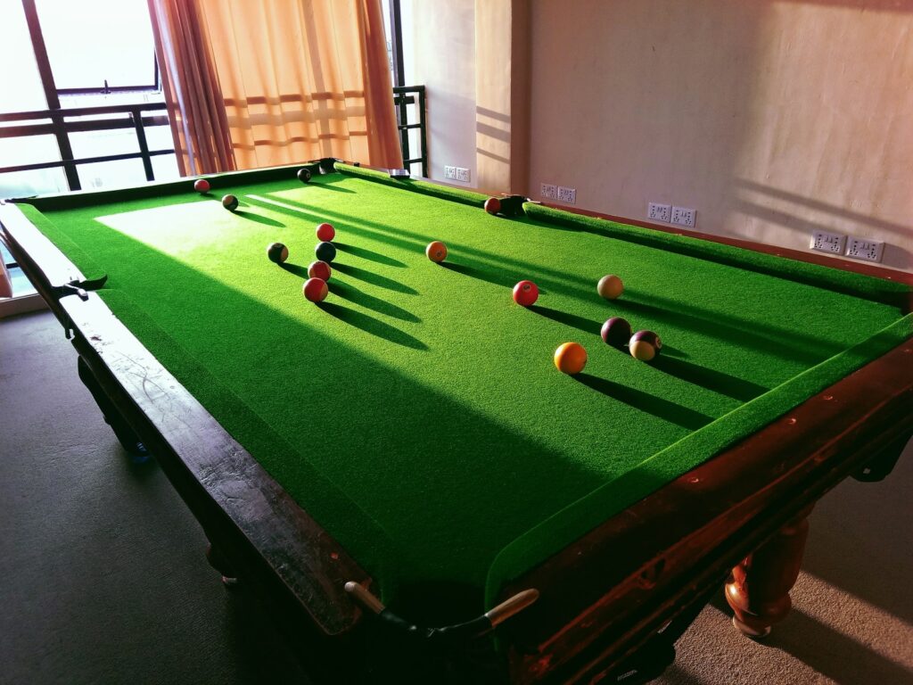 A pool table with a green cloth on it
